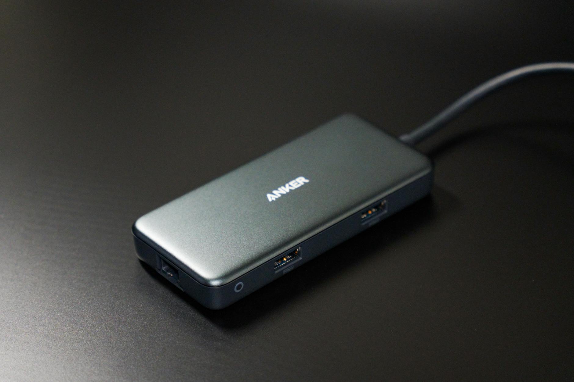 Kompaktowy hub USB-C z portami na ciemnym biurku