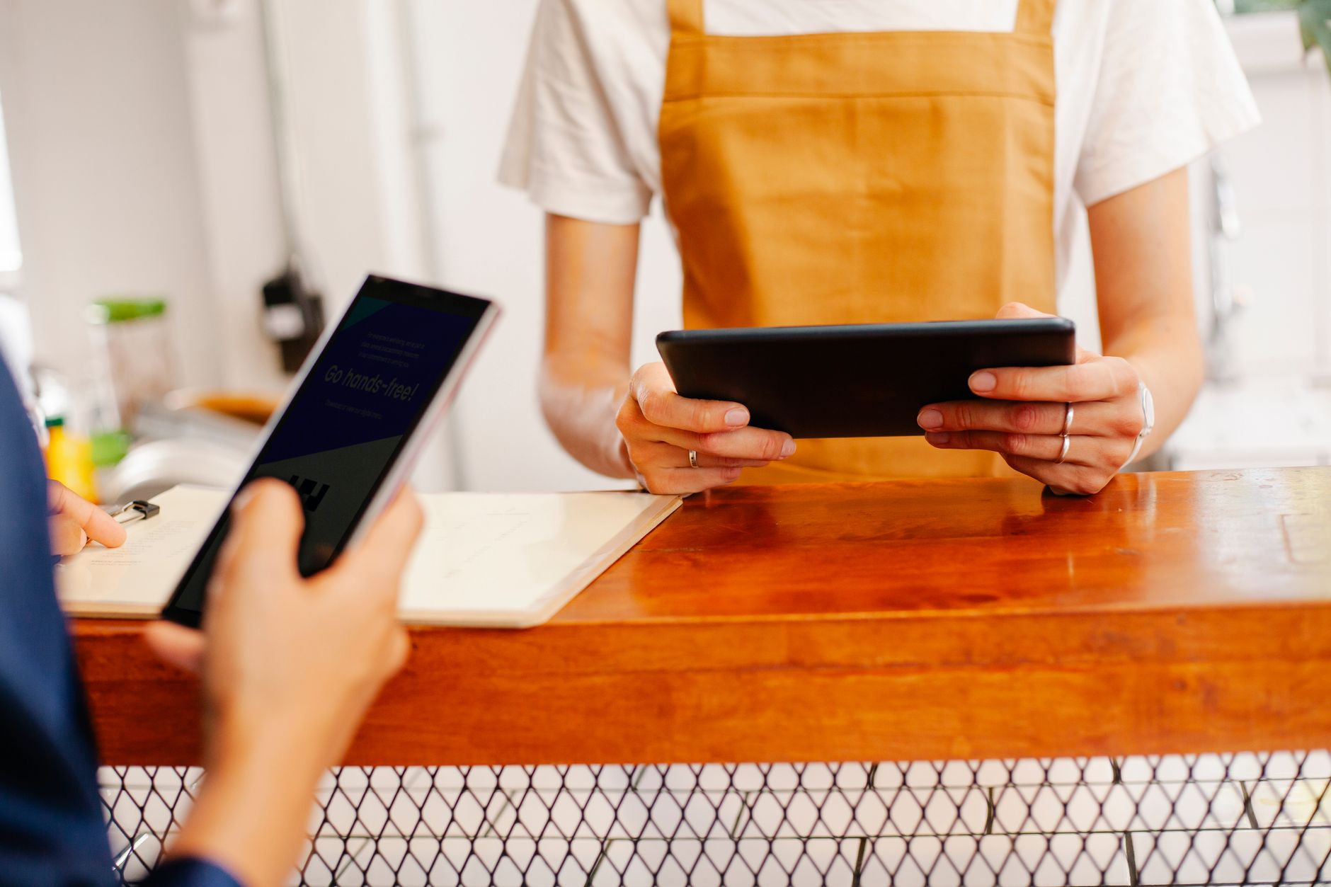 Kobiety w kawiarni omawiają pracę, korzystając ze smartfona i tabletu