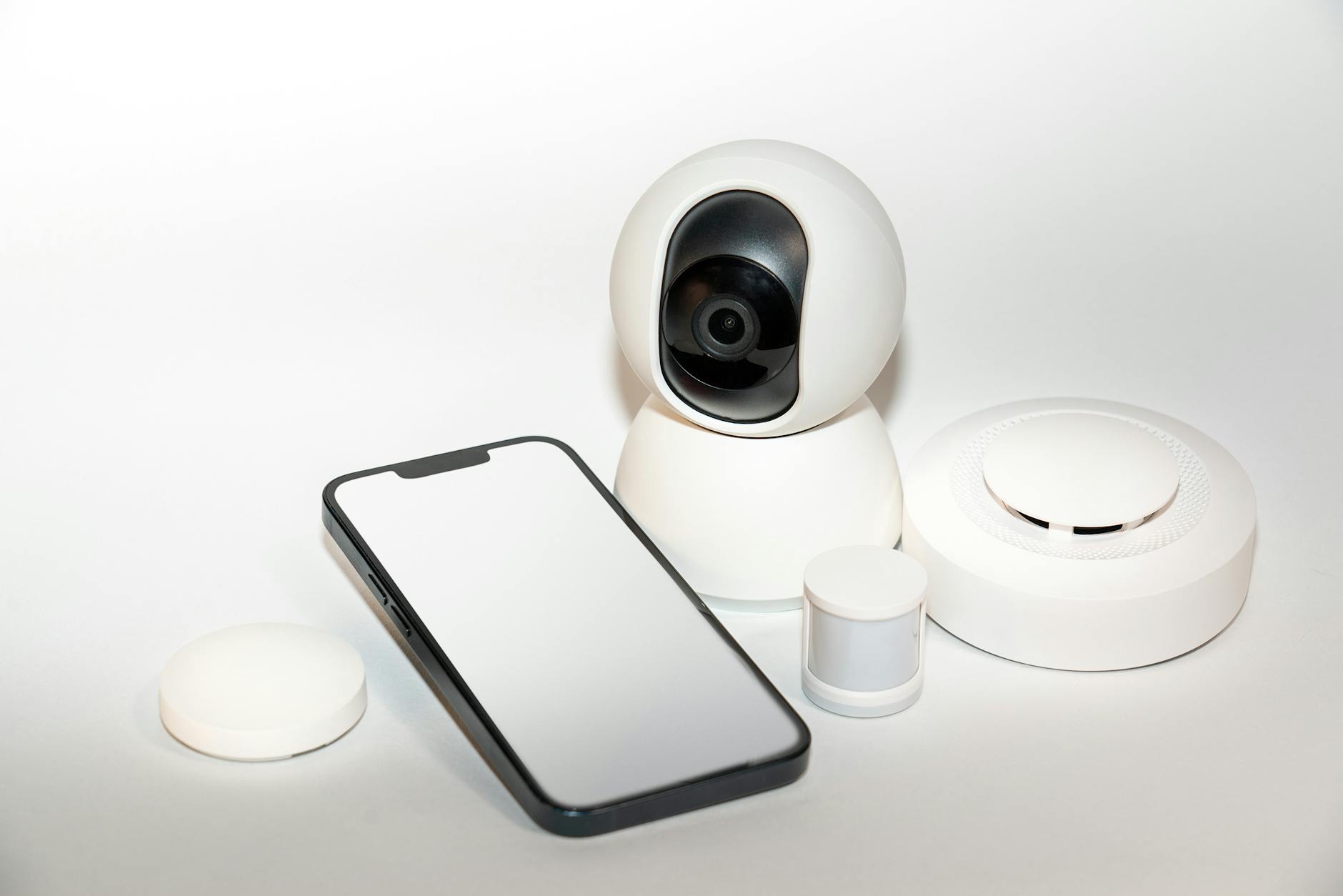 Zestaw domowych urządzeń IoT do monitoringu obok smartfona
