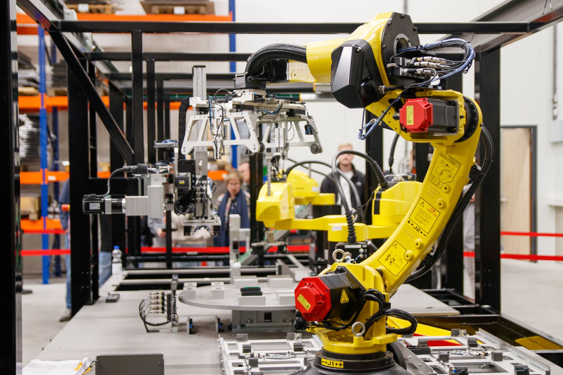 5G w przemyśle 4.0: autonomiczne roboty, predykcyjne utrzymanie ruchu i cyberbezpieczeństwo fabryk Żółte ramię robota przemysłowego pracujące w nowoczesnej fabryce