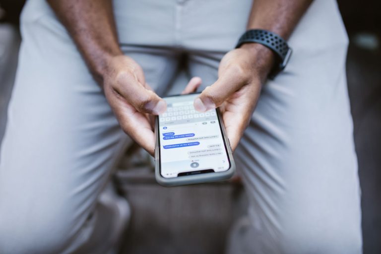 Mężczyzna piszący wiadomość SMS na smartfonie